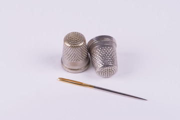 Two thimbles with a needle