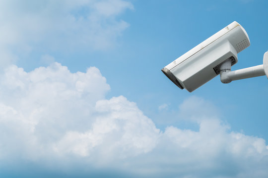 Surveillance camera on blue sky background