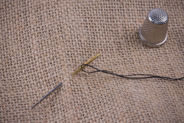 Needle, thread and thimble with sackcloth