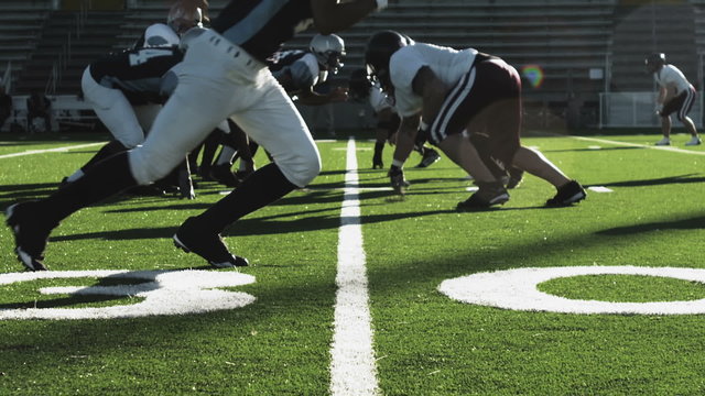 Low angle view of a football player running around the line to avoid tackles