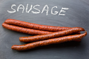 dried sausages on chalkboard