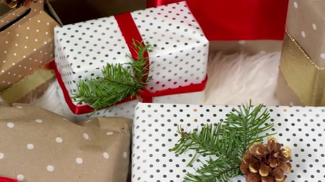 Close up pan of presents sitting under the tree on christmas morning