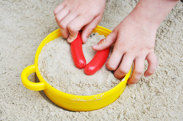 Kind kocht in einem Sandkasten