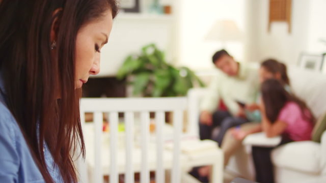 A mother uses a tablet computer to go over her families overdue bills