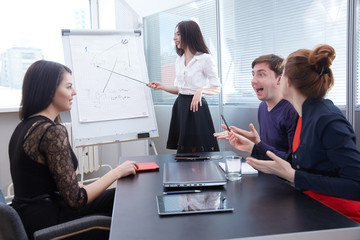 a group of businessmen in a meeting looking at the board