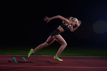 woman sprinter leaving starting blocks