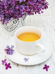 Cup of tea and lilac flowers