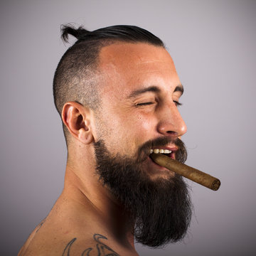 Hipster con puro gui&ntilde;ando ojo