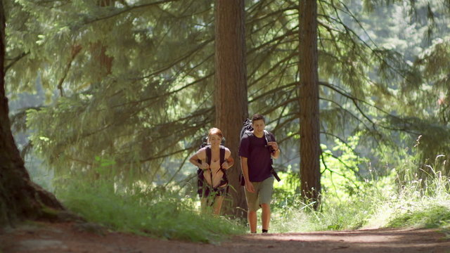 Fit and healthy young couple hiking through park