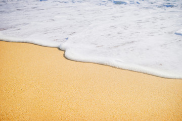 Fototapeta na wymiar Close-up of a water edge and sand. Summer beach background