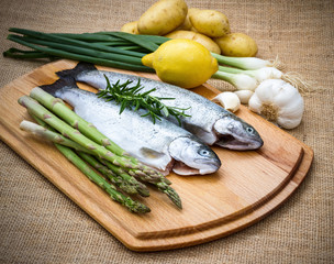 Two raw trout with green asparagus, ingredients