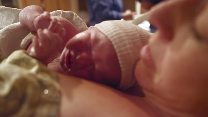 A newborn baby born just minutes before on her mothers chest