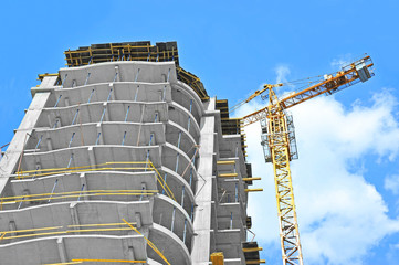 Crane and building construction site against blue sky