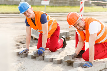 Workers laying cobblestones