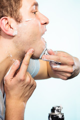 Man shaving with razor face profile