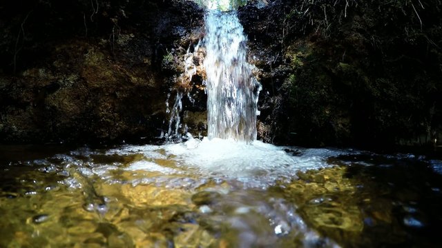 Pure fresh water waterfall in forest. Holy spring