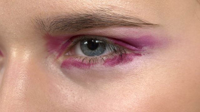 Eye make-up woman applying eyeshadow, making exotic,  two eyes