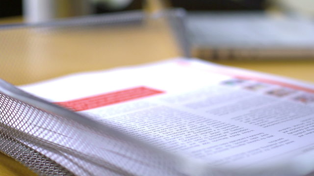 Papers keep on building up on desk while a man tries to keep up with filling