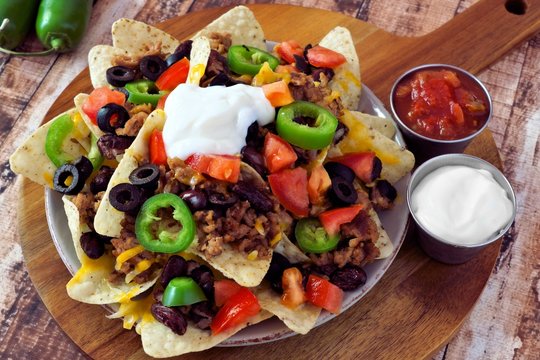 Mexican nachos with sour cream, meat, jalapenos, and cheese