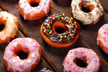 homemade colorful donuts on wooden background