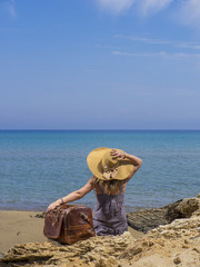 Fototapeta na wymiar Woman with leather travel bag on the beach