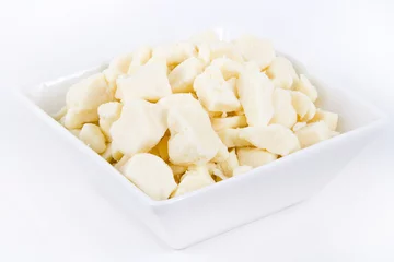 Fototapeten white dairy cheese curd in a bowl over white background © juliedeshaies