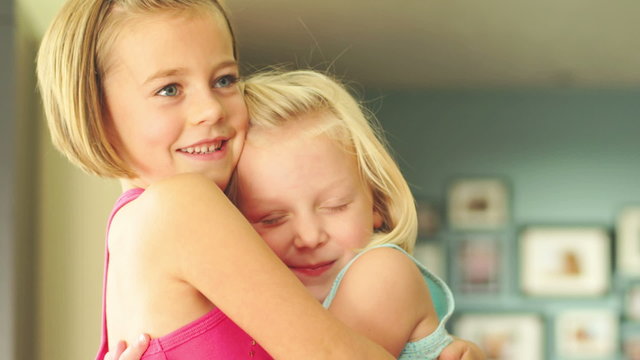 Two young girl friends hug and smile