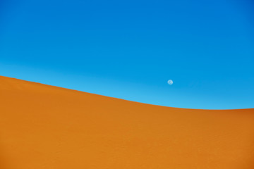 Sand dunes and almost full moon