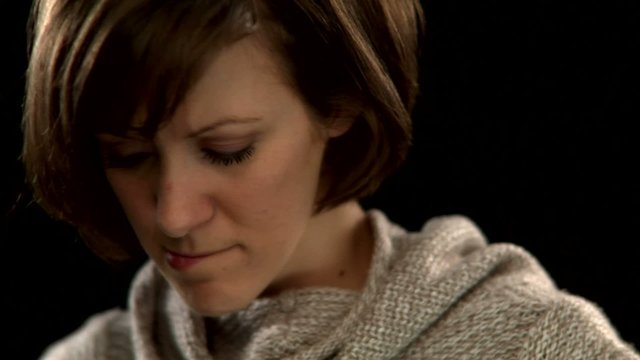 A woman with short hair looks pensive and unsure