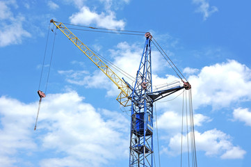 Old construction tower crane against blue sky