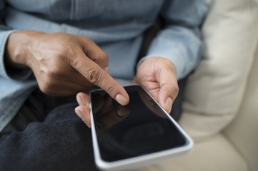 Men are using the latest smart phone sitting on the sofa