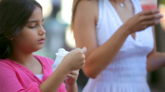 A young girl and her mother enjoy ice cream