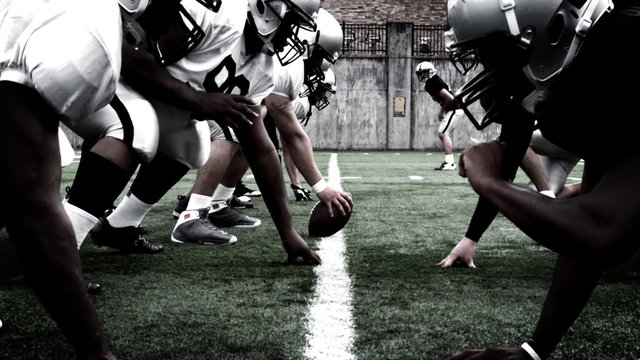 Football teams meet at the line of scrimmage