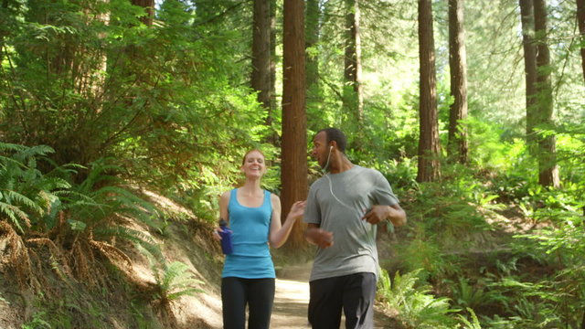 A couple jogging together in the forest