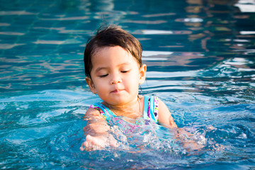 Fototapeta na wymiar Cute little girl having fun in the swimming pool