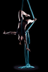 Young woman gymnast with blue gymnastic aerial silks