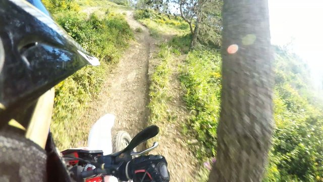 Enduro riding POV on mountain trails on a sunny day.