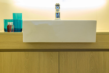 Modern style bathroom./ Bathroom sink counter towels water glass blue.
