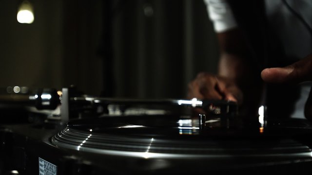 Close up of a DJ's hands spinning records at a party