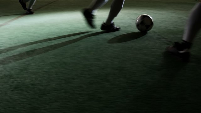 A soccer player dribbles the ball through foot traffic