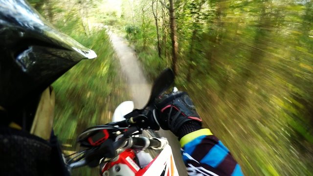 Enduro riding POV on mountain trails on a sunny day.