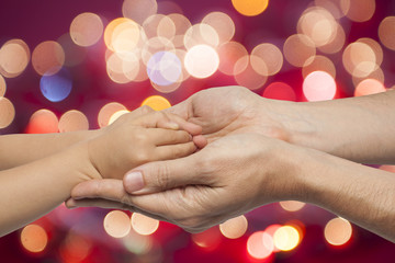 father and son holding hands on christmas lights background