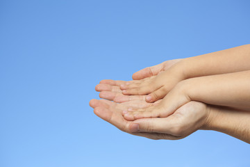 father and son holding hands on sky background