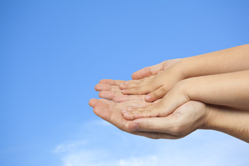 father and son holding hands on sky background