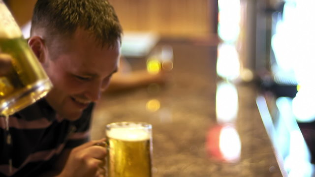 A close up shot of guys cheering with beers and sloshing some beer out of the steins