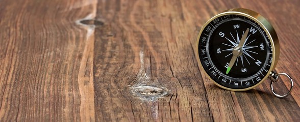 Gold Magnetic Compass On The Wood Board