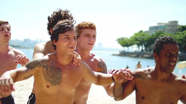 Friends compete to score a header on a beach.