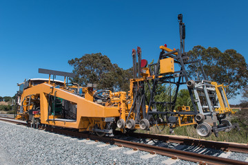 Railroad track machine for tamping and clamping