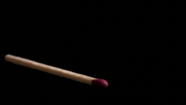 Close-Up footage of a match igniting and burning as it rotates.
