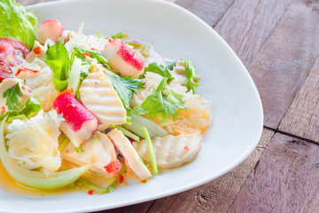 Thai cuisine spicy pork salad on wood background or Yum Moo Yor
